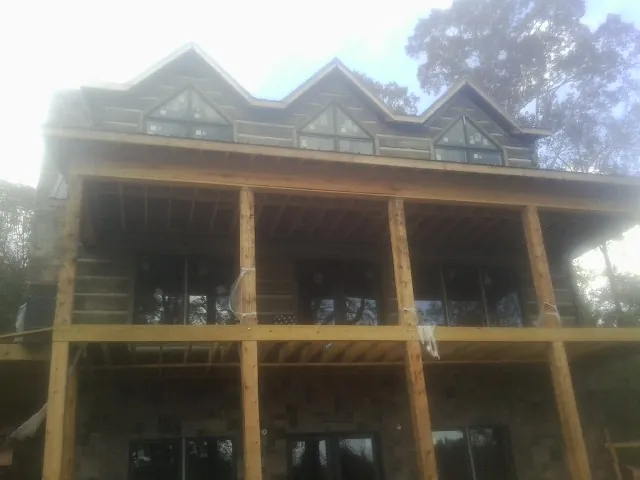 Dormers and porch framing on a large log home under construction — Roof Coating work by our crew in Hollidaysburg