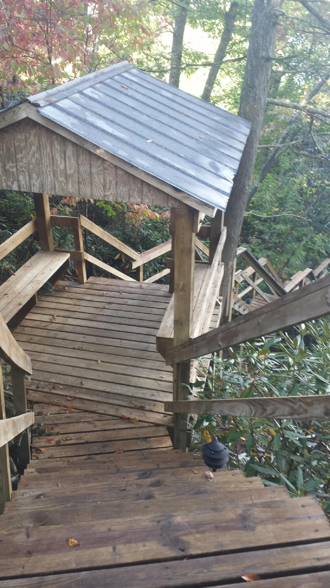 Metal roofed shelter over wooden steps on a wooded walkway — Skylight Repair & Installation work by our crew in Hollidaysburg
