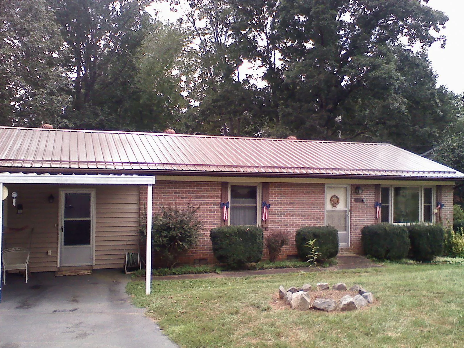 Bronze metal roof and carport on a brick ranch home — Roof Repair work by our crew in Hollidaysburg