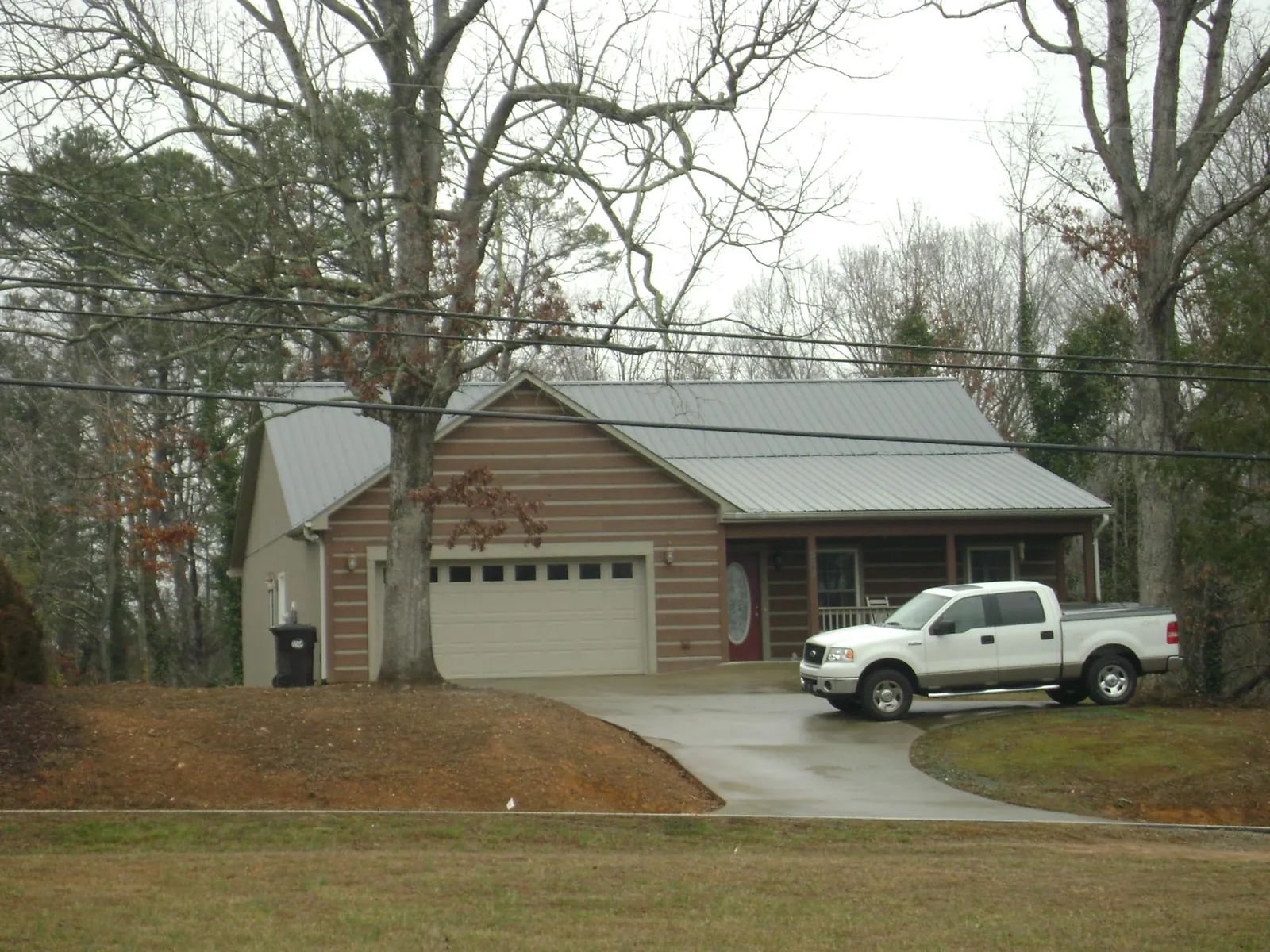 Gray metal roof on a log sided house with an attached two car garage in Hollidaysburg